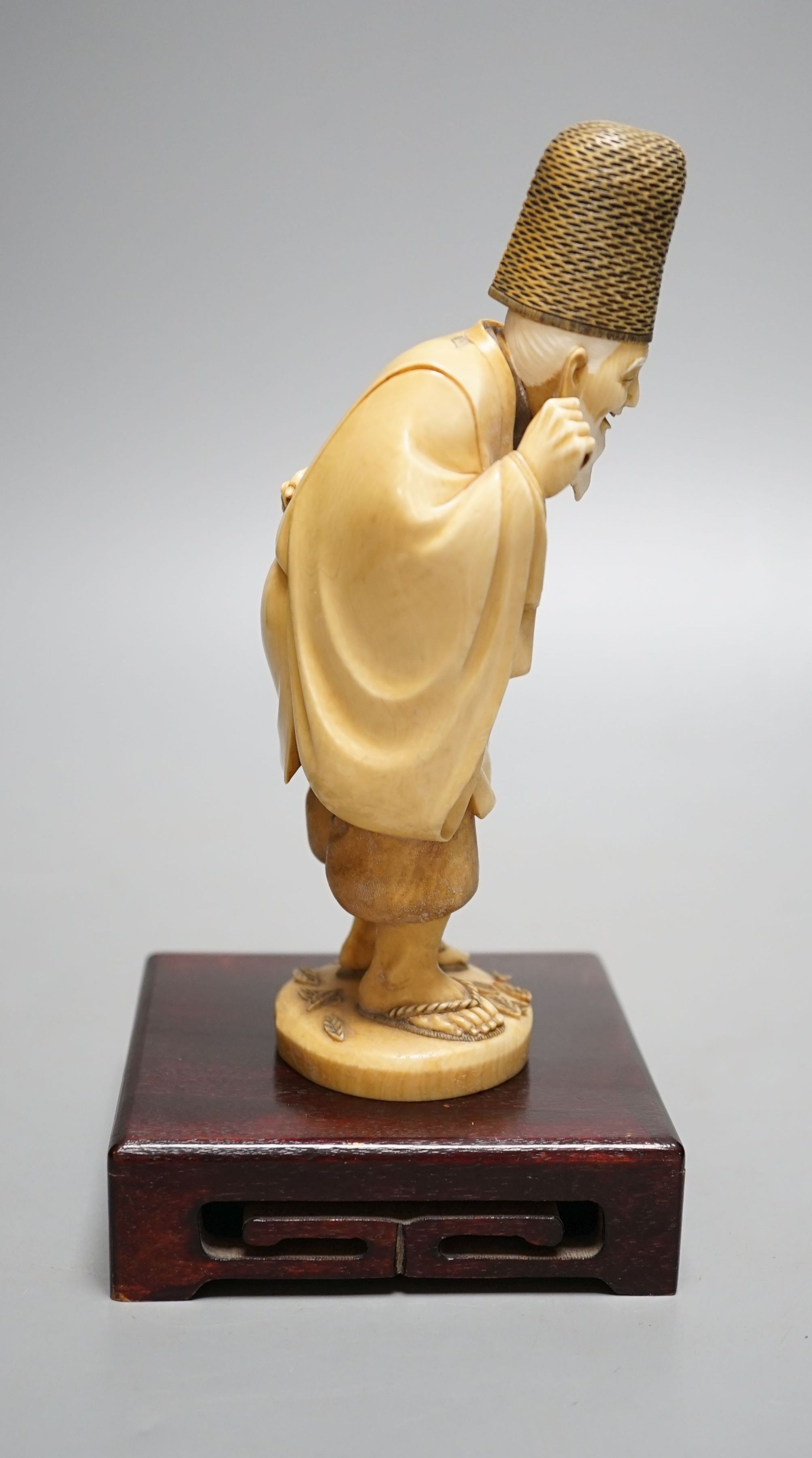 A Japanese ivory figure of a court official, wearing a tall eboshi hat, Taisho period, signed to a lacquer tablet - 18.5cm tall